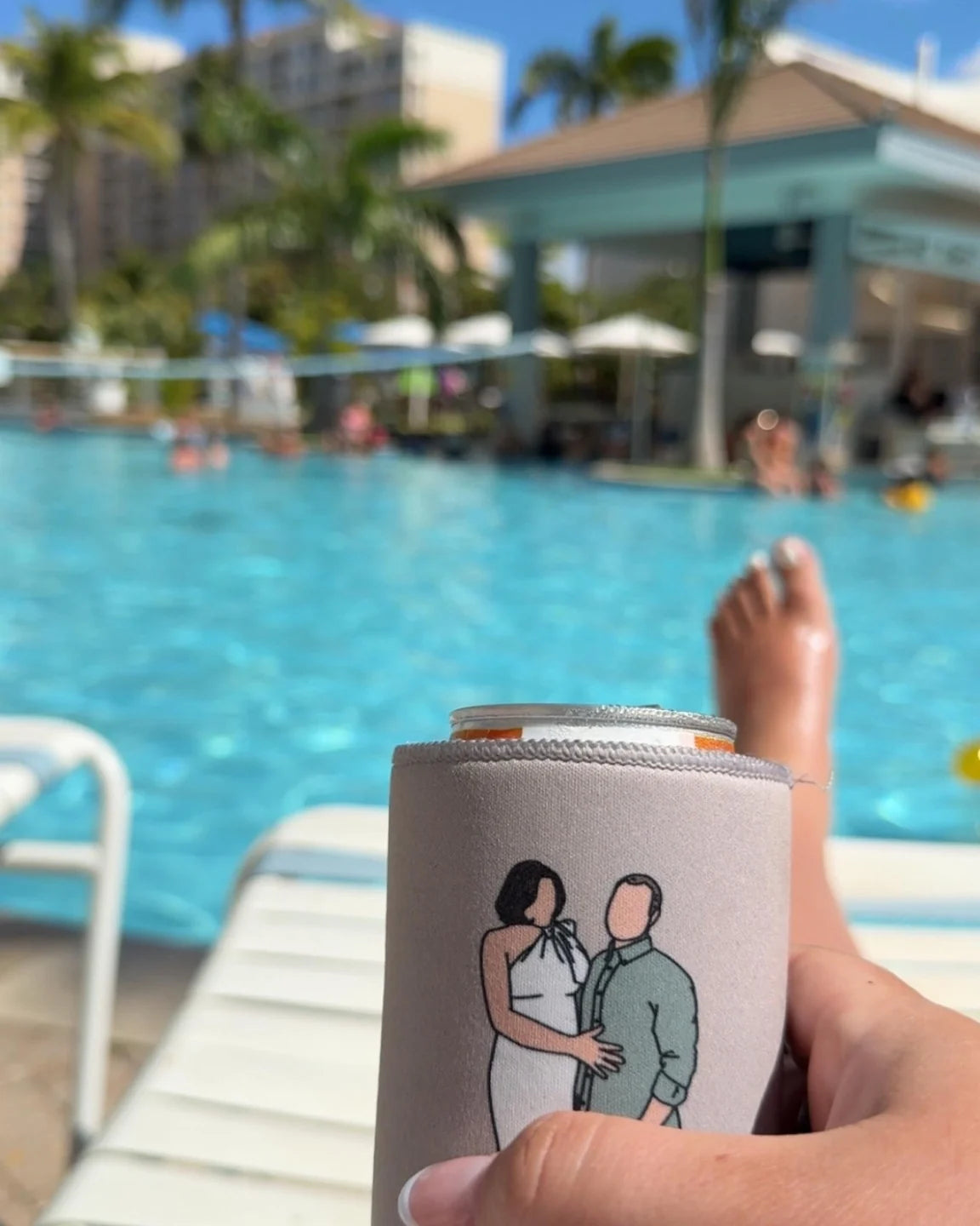 A hand-drawn portrait cooler held beside a swimming pool