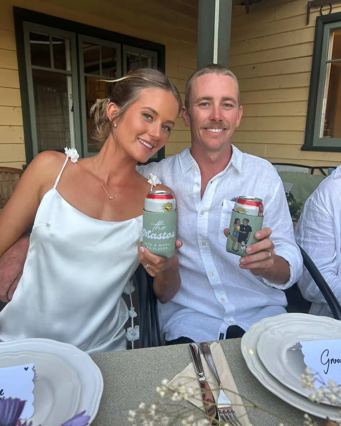 A couple showing their sage portrait and lettering can coolers